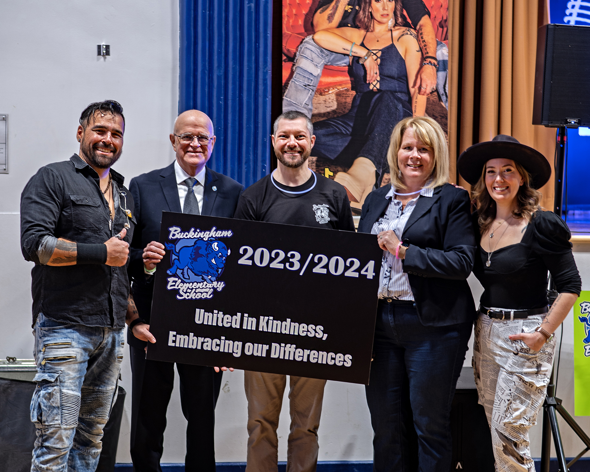 Group photo, L-R: Jaaji of Twin Flames, Chairman Wayne Daly, Principcal James Price, Director of Education Jennifer Dubeau, and Chelsey June of Twin Flames