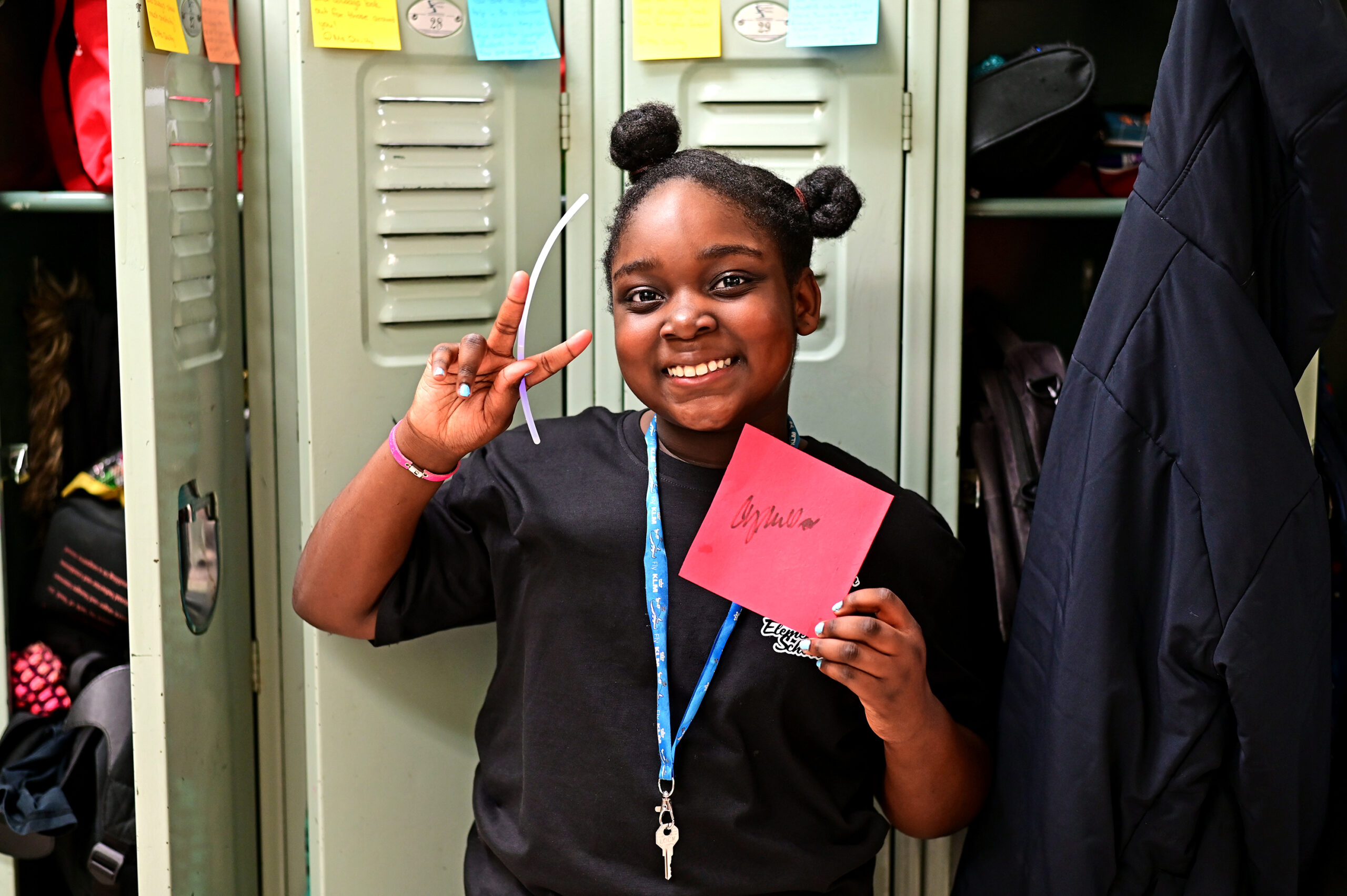 Student holds their autograph happily