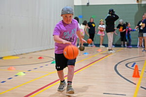 Student dribbling a basketball in the gym