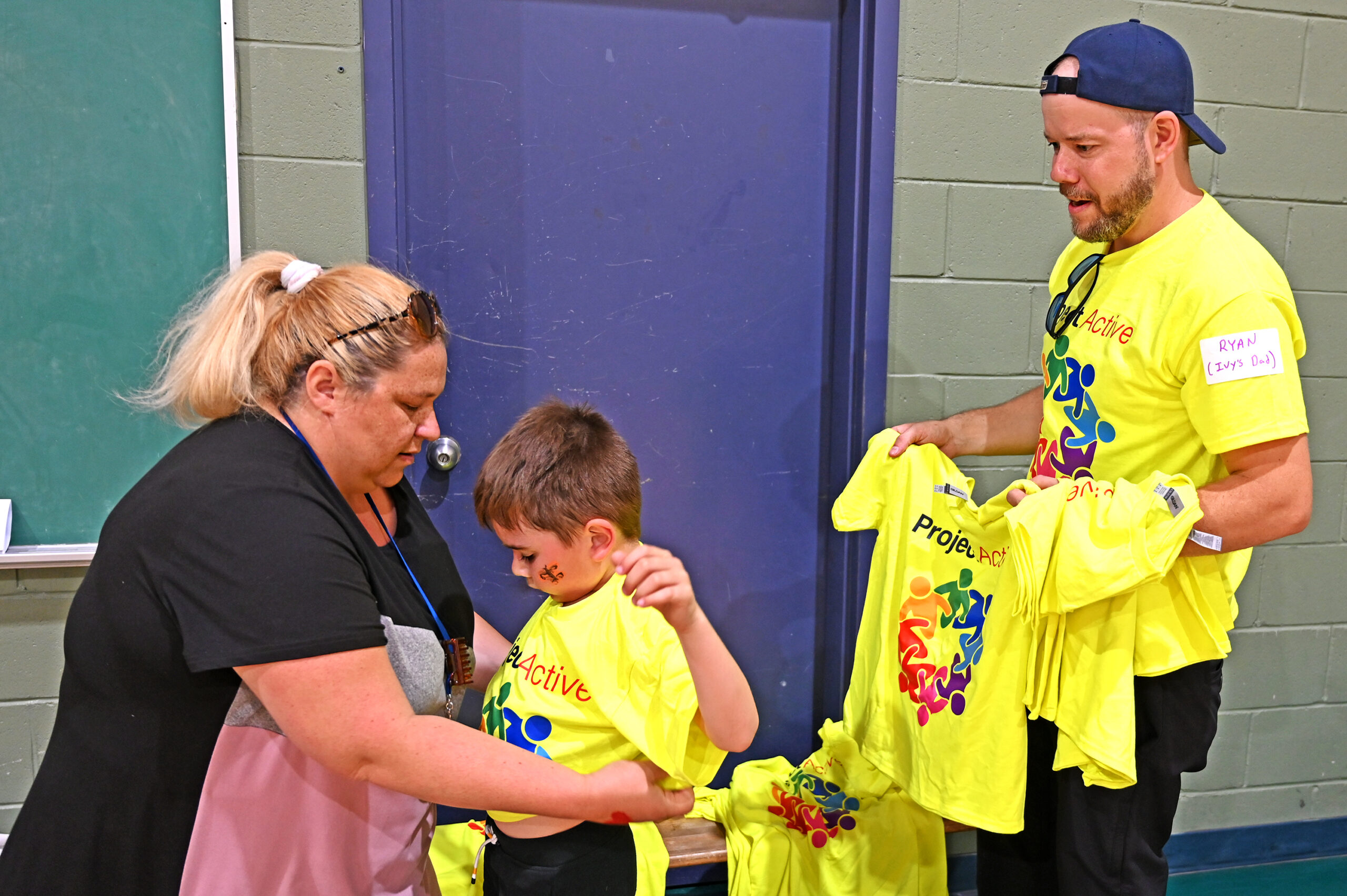 Eardley staff member adorns a students with a ProjectActive t-shirt