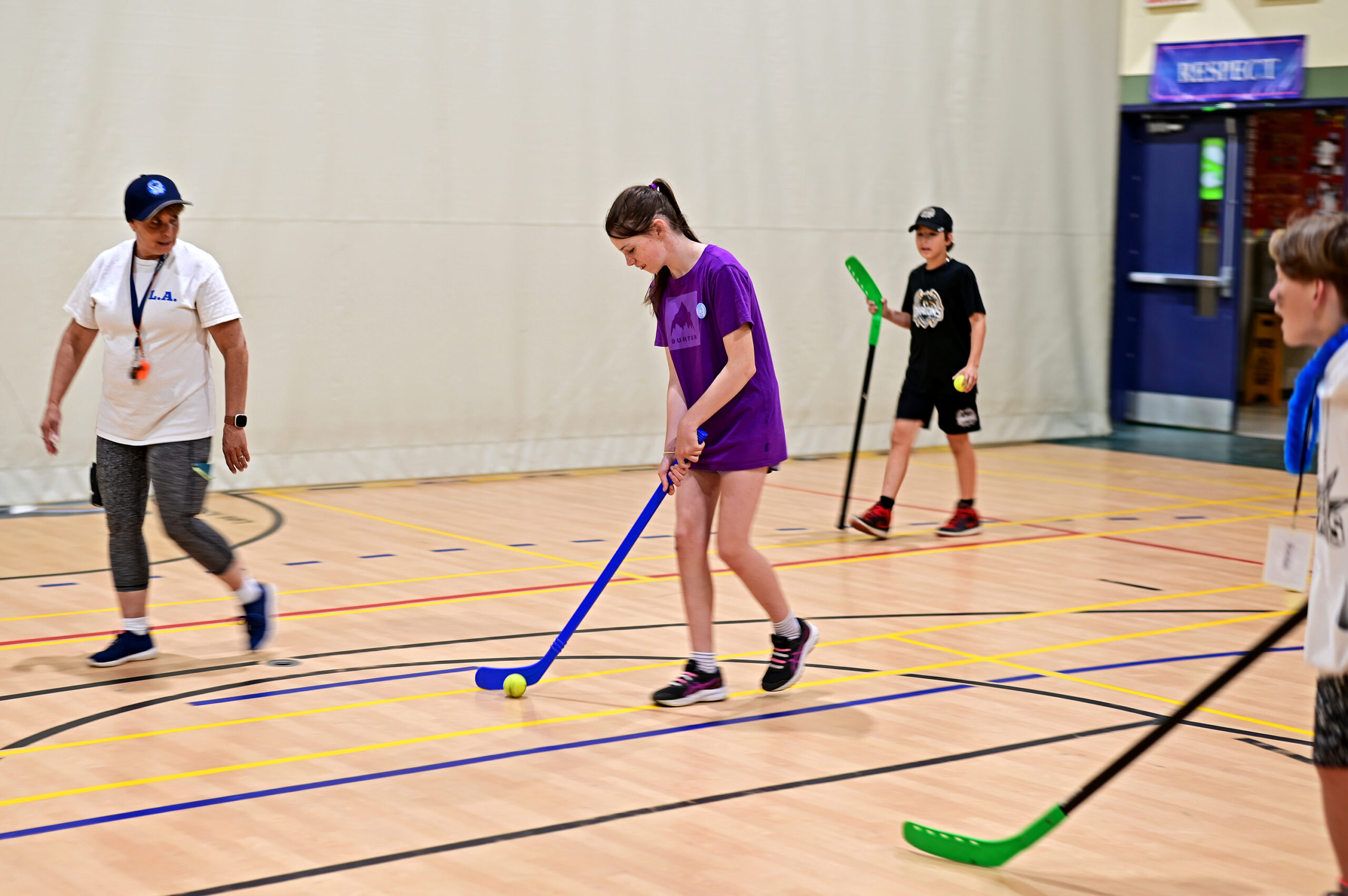 Students playing indoor hockey inside