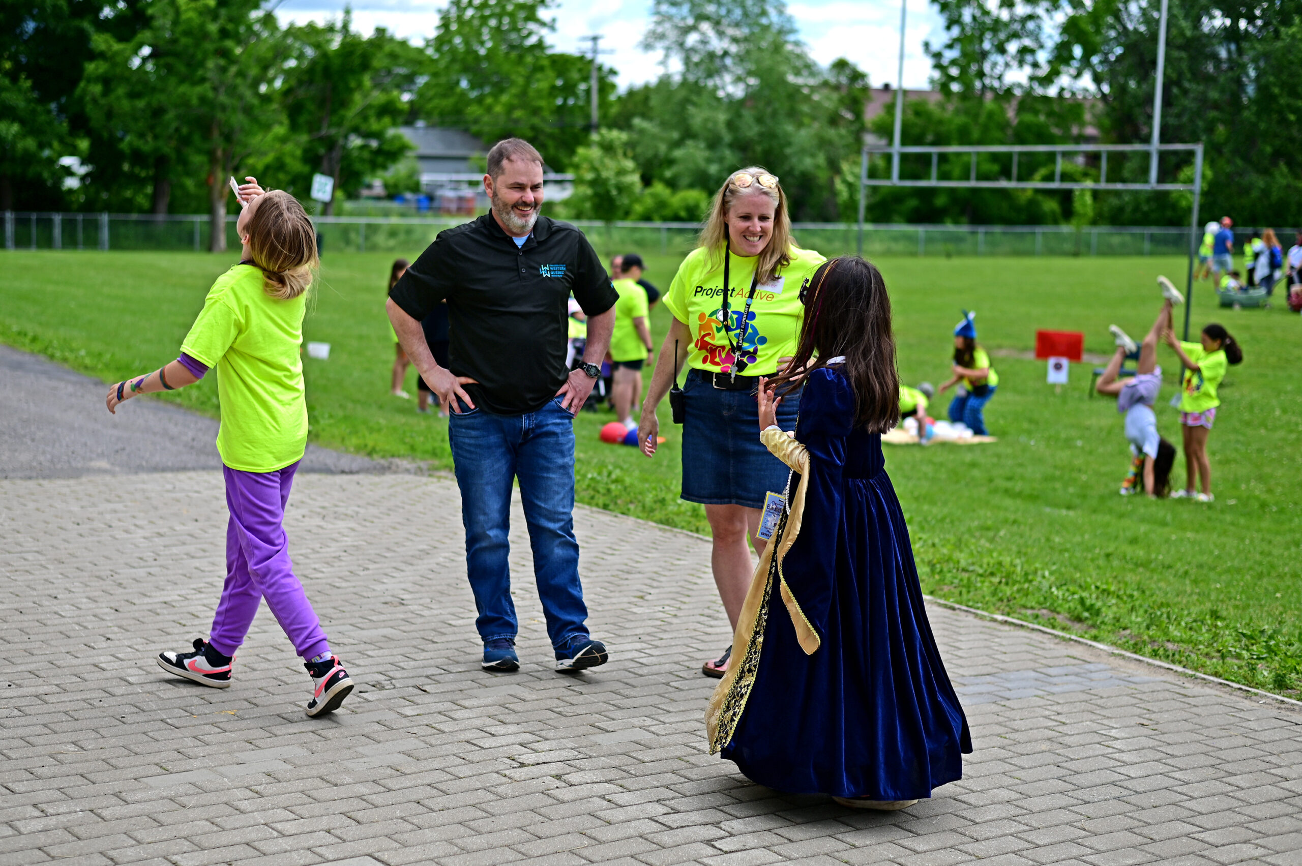 Principal Julia Horner and Secretary General and Director of Communications Eldon Keon smile widely while speaking with a student dressed like a princess