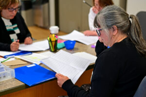 Three secondary V ELA teachers in deep focus reviewing exams