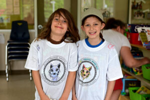 Two students pose for a photo with their newly coloured t-shirts
